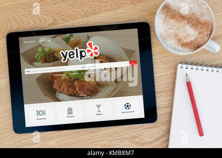 Der Yelp website Funktionen auf einem iPad Tablet Gerät, das auf einem Tisch liegt neben einem Notizblock und Bleistift und eine Tasse Kaffee (nur redaktionell) Stockfoto