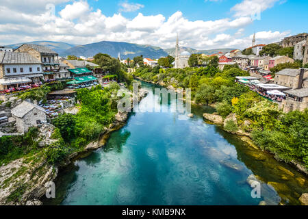 Anzeigen von Mostar und die Altstadt von der Alten Brücke mit einer Moschee, Minarett und Restaurant Cafés mit Blick auf den Fluss Neretva Stockfoto