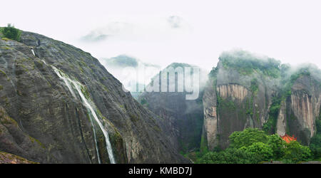 Panoramablick auf den schönen magischen Nebel bedeckte Berge mit kleinem Wasserfall und asiatischen Pagode, die zwischen den Bäumen in Fuzhou Mountains National p Stockfoto