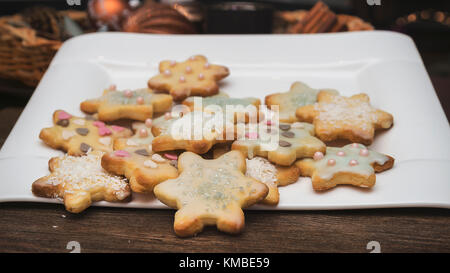 Backen für die Weihnachtszeit - kurze Kruste Gebäck Sterne mit Zitrone Puderzucker und Kokosraspeln Stockfoto