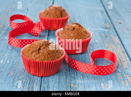Chocolate Muffins in rot Pappbecher mit einer Schleife dekoriert Stockfoto