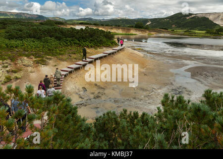 Touristen zu Fuß auf einer hölzernen Pfad in der uzon Caldera. kronotsky Naturschutzgebiet auf der Halbinsel Kamtschatka. Stockfoto