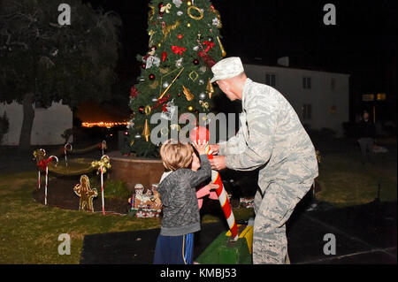 Der Kommandant der 61. Air Base Group, Col Charles Roberts, und einige seiner kleinen Helfer drehten den Schalter, um den Weihnachtsbaum in der Nähe des Paradegeländes auf Fort MacArthur, San Pedro, Kalifornien, anzuzünden, 29. November 2017. Anschließend wurden Familie, Freunde und Bewohner von Basiswohnungen mit Snacks, Spielzeug, Kunsthandwerk und einem Besuch mit dem Weihnachtsmann im Gemeindezentrum verwöhnt, um die Urlaubsstimmung in Gang zu bringen. (USA Luftwaffe Stockfoto