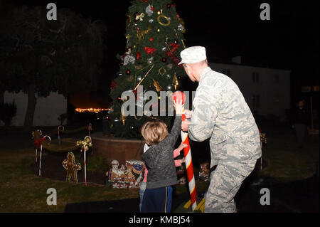 Der Kommandant der 61. Air Base Group, Col Charles Roberts, und einige seiner kleinen Helfer drehten den Schalter, um den Weihnachtsbaum in der Nähe des Paradegeländes auf Fort MacArthur, San Pedro, Kalifornien, anzuzünden, 29. November 2017. Anschließend wurden Familie, Freunde und Bewohner von Basiswohnungen mit Snacks, Spielzeug, Kunsthandwerk und einem Besuch mit dem Weihnachtsmann im Gemeindezentrum verwöhnt, um die Urlaubsstimmung in Gang zu bringen. (USA Luftwaffe Stockfoto