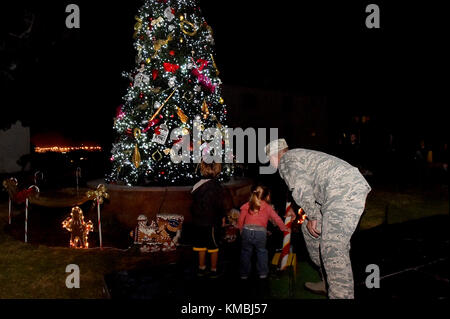 Der Kommandant der 61. Air Base Group, Col Charles Roberts, und einige seiner kleinen Helfer drehten den Schalter, um den Weihnachtsbaum in der Nähe des Paradegeländes auf Fort MacArthur, San Pedro, Kalifornien, anzuzünden, 29. November 2017. Anschließend wurden Familie, Freunde und Bewohner von Basiswohnungen mit Snacks, Spielzeug, Kunsthandwerk und einem Besuch mit dem Weihnachtsmann im Gemeindezentrum verwöhnt, um die Urlaubsstimmung in Gang zu bringen. (USA Luftwaffe Stockfoto