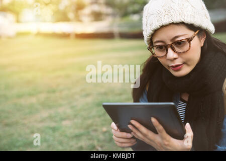 Nahaufnahme Blick auf die Casual Mädchen mit dem digitalen Tablet für e-learning im Park. Stockfoto