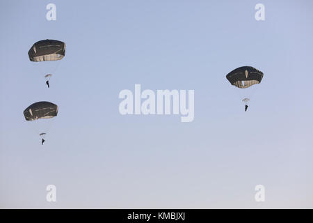 U.S. Army Fallschirmjäger füllen den Himmel in der Sicily Drop Zone für die 20. Jährliche Randy Oler Memorial Operation Toy Drop, veranstaltet von U.S. Army Civil Affairs & Psychological Operations Command (Airborne), 01. Dezember 2017 in Fort Bragg, North Carolina. Die Operation Toy Drop ist die weltweit größte kombinierte Flugoperation mit neun teilnehmenden Fallschirmjägern der Partnernation und ermöglicht es Soldaten, ihre militärischen Berufsspezialitäten zu trainieren, ihre Flugbereitschaft aufrechtzuerhalten und der lokalen Gemeinschaft etwas zurückzugeben. (USA Armee Stockfoto