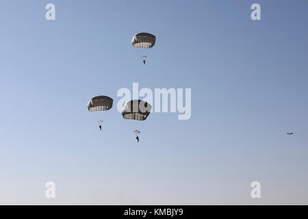 U.S. Army Fallschirmjäger füllen den Himmel in der Sicily Drop Zone für die 20. Jährliche Randy Oler Memorial Operation Toy Drop, veranstaltet von U.S. Army Civil Affairs & Psychological Operations Command (Airborne), 01. Dezember 2017 in Fort Bragg, North Carolina. Die Operation Toy Drop ist die weltweit größte kombinierte Flugoperation mit neun teilnehmenden Fallschirmjägern der Partnernation und ermöglicht es Soldaten, ihre militärischen Berufsspezialitäten zu trainieren, ihre Flugbereitschaft aufrechtzuerhalten und der lokalen Gemeinschaft etwas zurückzugeben. (USA Armee Stockfoto