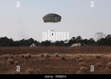 U.S. Army Fallschirmjäger füllen den Himmel in der Sicily Drop Zone für die 20. Jährliche Randy Oler Memorial Operation Toy Drop, veranstaltet von U.S. Army Civil Affairs & Psychological Operations Command (Airborne), 01. Dezember 2017 in Fort Bragg, North Carolina. Die Operation Toy Drop ist die weltweit größte kombinierte Flugoperation mit neun teilnehmenden Fallschirmjägern der Partnernation und ermöglicht es Soldaten, ihre militärischen Berufsspezialitäten zu trainieren, ihre Flugbereitschaft aufrechtzuerhalten und der lokalen Gemeinschaft etwas zurückzugeben. (USA Armee Stockfoto