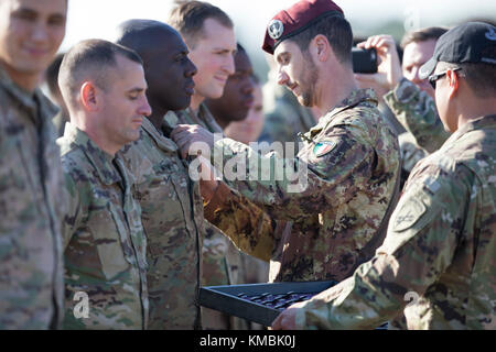 Fallschirmjäger der US-Armee erhalten ihre ausländischen Sprungflügel von einem italienischen Jumpmaster nach ihrer Teilnahme an der 20th Annual Randy Oler Memorial Operation Toy Drop, veranstaltet vom U.S. Army Civil Affairs & Psychological Operations Command (Airborne), 01. Dezember 2017 in der Sicily Drop Zone. Operation Toy Drop ist die weltweit größte kombinierte Luft und ermöglicht Soldaten die Möglichkeit, auf ihre militärische berufliche Spezialität trainieren, ihre Luftbereitschaft aufrecht zu erhalten, und geben zurück an die lokale Gemeinschaft. (USA Armee Stockfoto