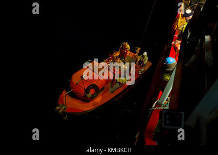 Segler, die dem Unmanned Undersea Vehicle Squadron 1 (UUVRON 1) zugewiesen wurden, die mit dem Undersea Rescue Command (URC) operieren, steigen mit Hilfe von Besatzungsmitgliedern und argentinischen Navy-Partnern in einem kleinen Boot vom norwegischen Bauunterstützungsschiff Skandi Patagonia aus, um ein unbemanntes Unterwasserfahrzeug (UUV) einzusetzen. Undersea Rescue Command, die einzige U-Boot-Rettungseinheit der US Navy, mobilisierte, um die Such- und Rettungsbemühungen der argentinischen Regierung für das Diesel-elektrische U-Boot A.R.A. der argentinischen Navy zu unterstützen San Juan (S 42). (USA Marineblau Stockfoto