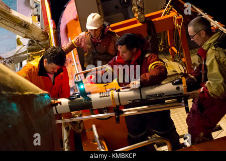 Segler, die dem Unmanned Undersea Vehicle Squadron 1 (UUVRON 1) zugeordnet sind und mit dem Undersea Rescue Command (URC) operieren, Bergen ein unbemanntes Unterwasserfahrzeug (UUV) von einem kleinen Boot auf das norwegische Bauunterstützungsschiff Skandi Patagonia, mit Hilfe von Besatzungsmitgliedern und argentinischen Navy Partnern. Undersea Rescue Command, die einzige U-Boot-Rettungseinheit der US Navy, mobilisierte, um die Such- und Rettungsbemühungen der argentinischen Regierung für das Diesel-elektrische U-Boot A.R.A. der argentinischen Navy zu unterstützen San Juan (S 42). (USA Marineblau Stockfoto