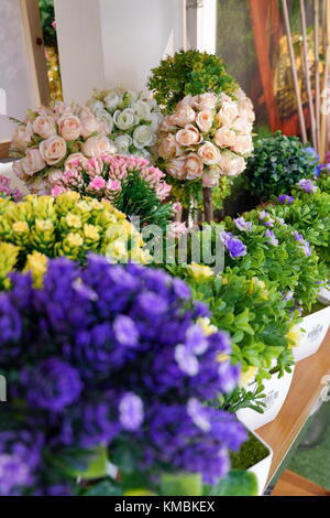 Künstliche violett blühenden Pflanzen auf dem Display sieht frisch und realen Hintergrund im Fokus Stockfoto