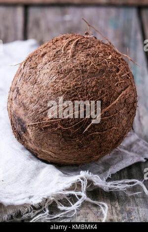 Ganze Kokosnuss auf alten Holztisch Stockfoto