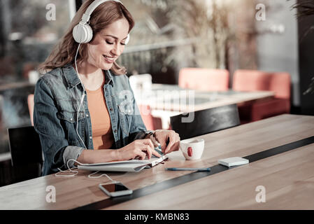 Lächelnden jungen Frau in einen produktiven Morgen im Cafe Stockfoto