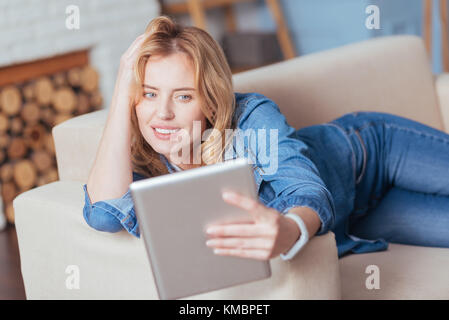 Erstaunlich junge Frau ein Foto, während er auf einem Sofa Stockfoto