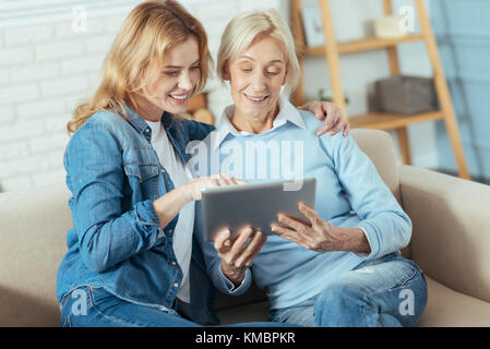 Fröhliche junge Frau Fotos zeigen ihre Oma und lächelnd Stockfoto