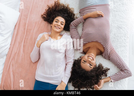 Cute curly blonde Schwestern entspannen auf Bett Stockfoto