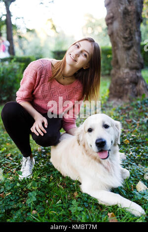 Bild der Frau umarmen Hund auf Rasen Stockfoto