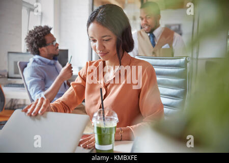 Geschäftsfrau öffnet Laptop, arbeitet im Büro Stockfoto