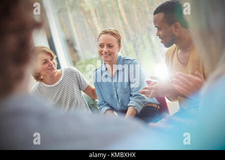 Die Leute klatschen für Frau in der Gruppe Therapie Sitzung Stockfoto