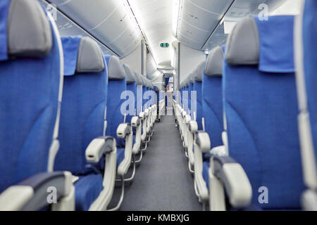 Leere blaue Sitze in einer Reihe im Flugzeug Stockfoto