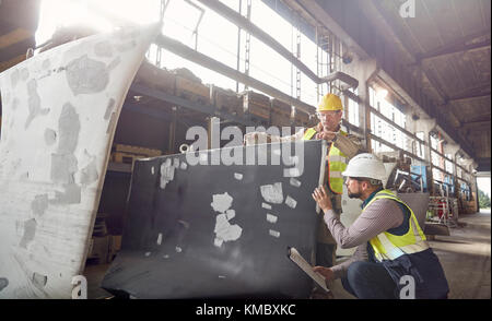 Stahlarbeiter untersuchen Stahlteil in Stahlwerk Stockfoto