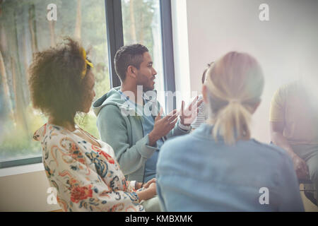 Mann spricht und gestikuliert in der Gruppentherapie Sitzung Stockfoto