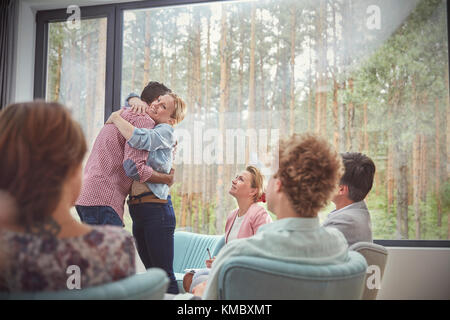 Mann und Frau umarmen in Gruppe Therapie Sitzung Stockfoto