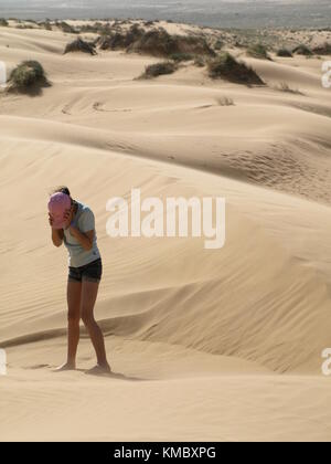 Mädchen stehen auf Sand Dune und über ihr Gesicht von Sandsturm in der Wüste Stockfoto