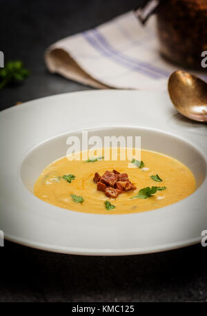 Rote Linsensuppe mit gegrillten Würstchen in Weiß Platte auf dunklem Stein Stockfoto