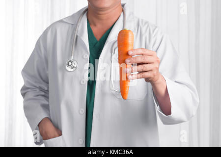 Krankenschwester oder männlicher Arzt, der einer Apple lächelnd. health care Konzept auf weißem Hintergrund. Stockfoto