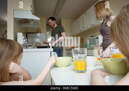 Vater, Mutter und Tochter, die an der Zubereitung der Speisen in der Küche auf der Suche Stockfoto