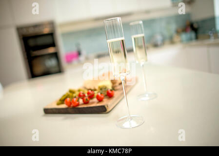 Champagnergläser und Essen auf den Küchentisch Stockfoto
