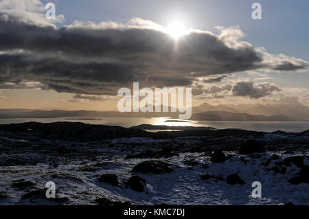 Ein Schnee Szene ansehen und die Sonne über dem Cullin Berge auf der Isle of Skye an der Westküste von Schottland. Stockfoto