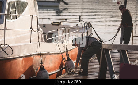 Fischer binden Boje auf dem Boot Stockfoto