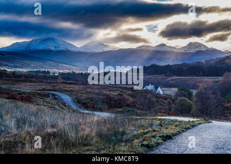 Der Blick nach Süden um von Dalrigh, südlich von tyndrum. Wie die Sonne über dem Crianlarich Hügel - Ben Mehr, Stob und Binnein Cruach Ardrain. Stockfoto