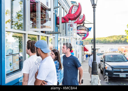 Bar Harbor, USA - Juni 8, 2017: Menschen zu Fuß auf dem Bürgersteig bei Sonnenuntergang in der Innenstadt von Dorf im Sommer Blick auf Restaurants Menu Stockfoto