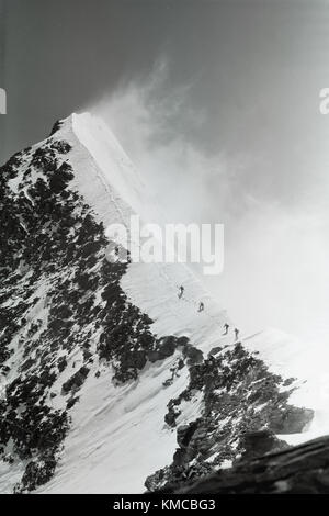 Aufstieg zum Gipfel des Kommunismus (somoni) ist 7.495 m, Kletterer klettern auf einem schneebedeckten Hang high mountain unter Wolken und Nebel, Pamir, Tadschikistan, 1970 fi Stockfoto