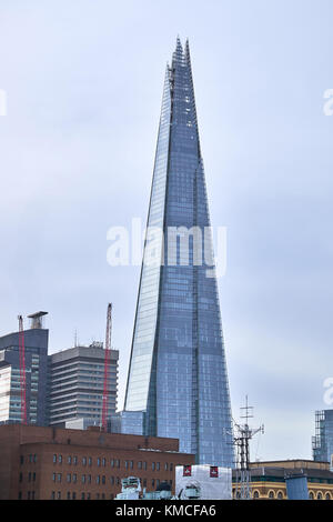 London City - Dezember 24, 2016: Die Spitzen Wolkenkratzer Shard zu einem grauen Himmel steigenden unter den niedrigeren Gebäuden Stockfoto