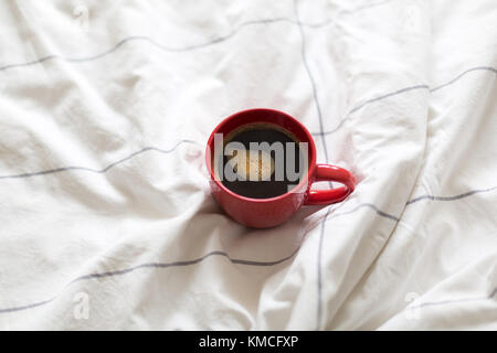 Kaffee in rot Schale serviert im Bett Stockfoto