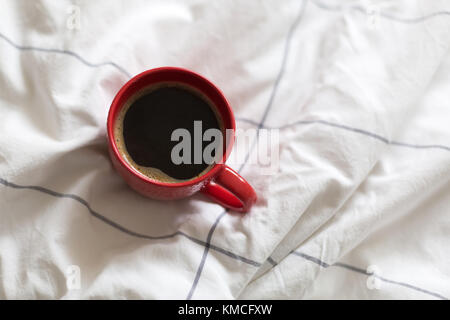 Kaffee in rot Schale serviert im Bett Stockfoto