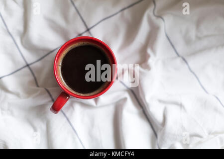 Kaffee in rot Schale serviert im Bett Stockfoto
