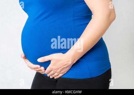 Schwangere Frau hält die Hände auf ihren Magen, Konzept von Gesundheit Pflege und Blase Schmerzen oder Blasenentzündung im letzten Trimester der Schwangerschaft Stockfoto