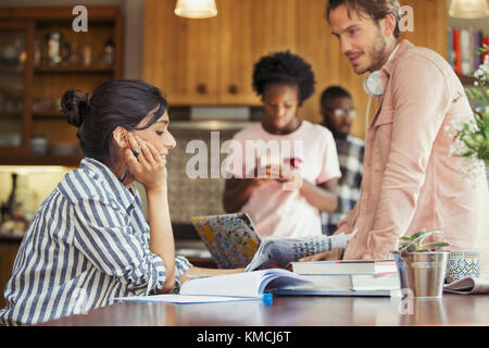 Freunde Mitbewohner arbeiten und lesen Zeitung am Esstisch Stockfoto