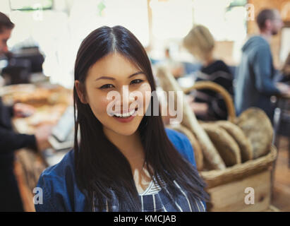 Portrait lächelnde junge Frau im Lebensmittelgeschäft Stockfoto