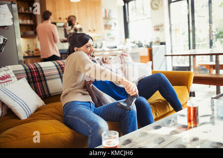 Verspielte Frau spielt Videospiel auf Wohnzimmer Sofa Stockfoto
