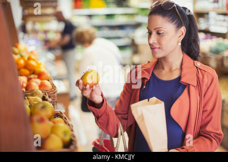 Frau einkaufen, untersuchen Apfel im Lebensmittelgeschäft Stockfoto