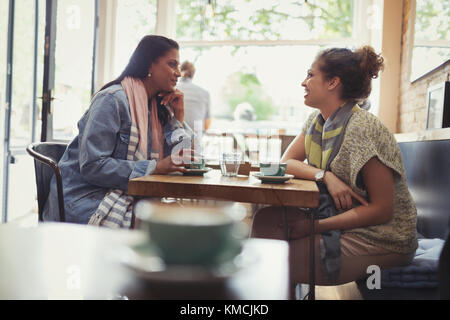 Freundinnen Kaffee trinken und reden am Café-Tisch Stockfoto