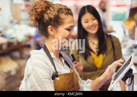 Weibliche Kassiererin, die den Kunden an der Touchscreen-Kasse hilft Lebensmittelgeschäft Stockfoto